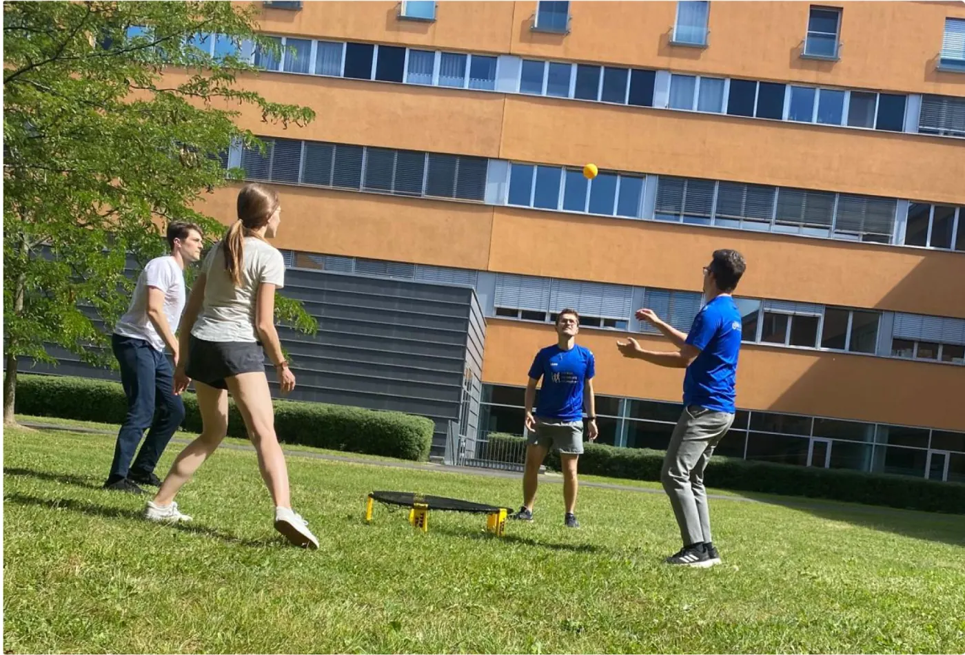 Team members playing spikeball together outdoors